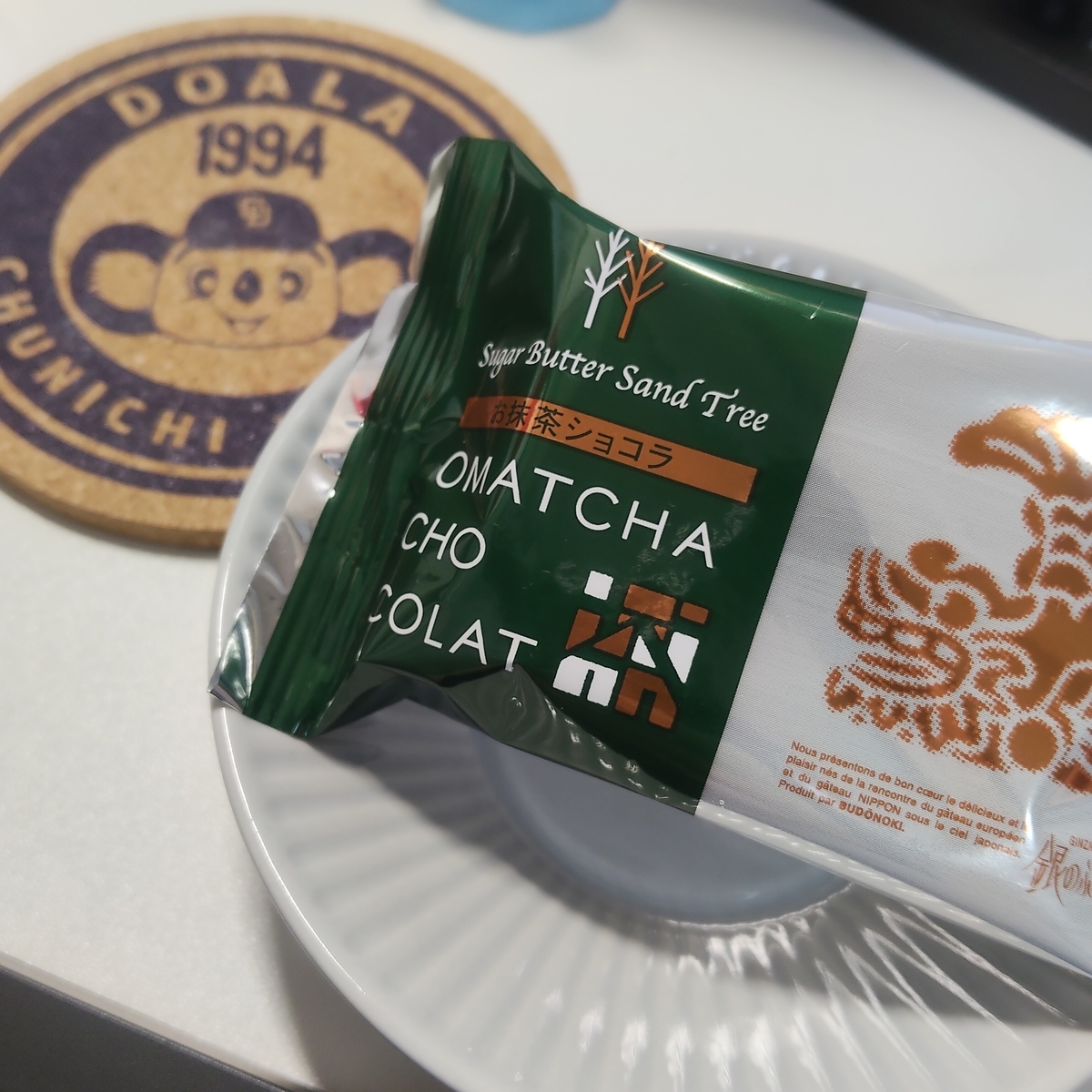 滲み寄る名古屋　ドアラの上にマグカップ